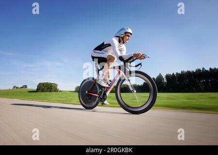 Cycliste masculin avec roue à disque sur la route près de Munsing, haute-Bavière, Allemagne Banque D'Images