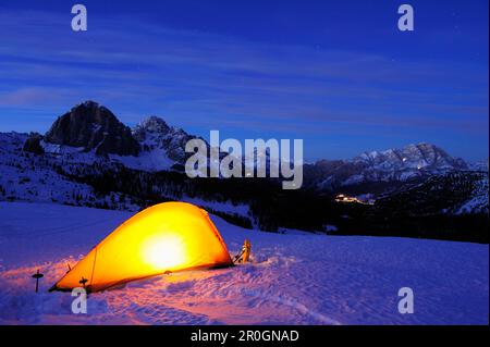 Tente illuminée sur le front de neige, Tofana, Cristallo et Cortina d'Ampezzo en arrière-plan, Passo Giau, Cortina d'Ampezzo, site classé au patrimoine mondial de l'UNESCO Dolom Banque D'Images