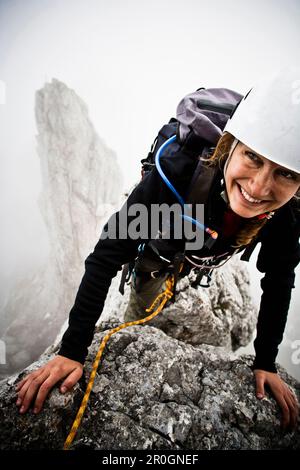 Femme Kopftoerlgrat Kapuzenturm à l'alpiniste, en arrière-plan, Ellmauer Halt, Kaiser, Tyrol, Autriche Banque D'Images