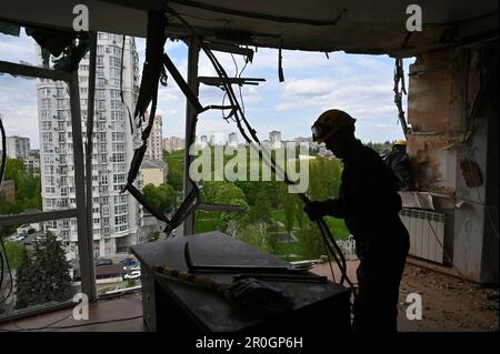 Kiev, Ukraine. 08th mai 2023. Sauveteurs vus dans un bâtiment résidentiel de plusieurs étages endommagé par un shrapnel d'un drone kamikaze abattu de l'armée russe. Dans la nuit de 8 mai, l'armée russe a attaqué la région de Kiev avec des drones de choc fabriqués par l'Iran, « Shhahed ». L'armée ukrainienne a détruit 35 drones russes sur 35 tirés à Kiev. Dans la ville, en raison de la chute de débris, des maisons, des surfaces de route et des voitures ont été endommagées. Cinq personnes ont été blessées. Crédit : SOPA Images Limited/Alamy Live News Banque D'Images