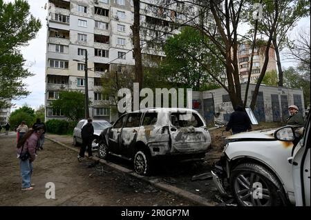 Kiev, Ukraine. 08th mai 2023. Les gens qui regardent des voitures endommagées par des fragments d'un drone kamikaze abattu de l'armée russe. Dans la nuit de 8 mai, l'armée russe a attaqué la région de Kiev avec des drones de choc fabriqués par l'Iran, « Shhahed ». L'armée ukrainienne a détruit 35 drones russes sur 35 tirés à Kiev. Dans la ville, en raison de la chute de débris, des maisons, des surfaces de route et des voitures ont été endommagées. Cinq personnes ont été blessées. Crédit : SOPA Images Limited/Alamy Live News Banque D'Images