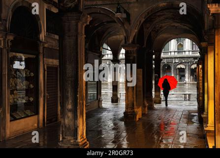 Une femme avec parapluie rouge, reliant passage à la Piazza San Marco, Venise, Italie Banque D'Images