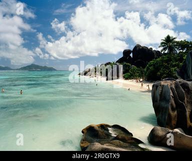 Touristes sur la plage la plus célèbre des mondes Anse Source d'argent avec ses roches granitiques, le sud-ouest de la Digue, la Digue et les îles intérieures, République de Sey Banque D'Images