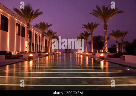 La piscine, l'hôtel The Chedi Muscat au crépuscule, Muscat, Mascate, Oman, Péninsule Arabique Banque D'Images