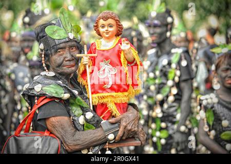 Vieille femme tenant un figur de Santo Nino, festival d'ATI Atihan, Kalibo, Aklan, île de Panay, Visayas, Philippines Banque D'Images