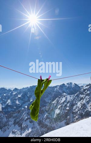 Chaussettes vertes sur corde à linge au soleil, vue sur les montagnes Wetterstein et Karwendel, Alpspitze, Alpes, Bavière, Allemagne, Europe Banque D'Images