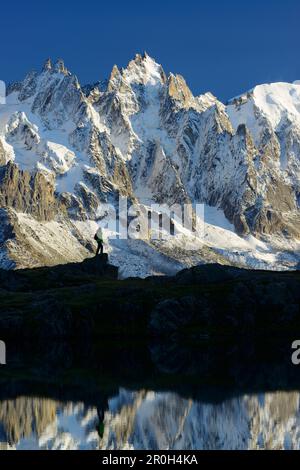 Femme randonnée à proximité d'un lac de montagne avec les aiguilles du Chamonix en arrière-plan, massif du Mont blanc, Chamonix, Savoie, France Banque D'Images