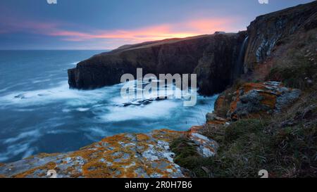 Ciel nocturne rouge sur les falaises spectaculaires de Whaligoe dans les Highlands du Nord-est, Écosse, Royaume-Uni Banque D'Images