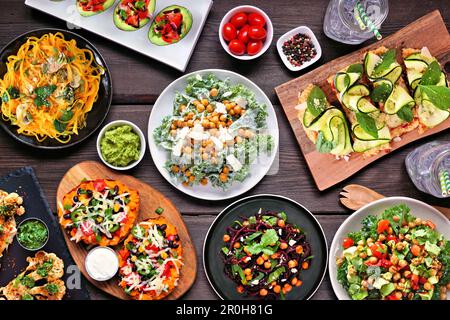 Scène saine de table de carb à base de plantes. Vue en hauteur sur fond de bois sombre. Nouilles de légumes, pain plat de chou-fleur et steaks, chou-fleur sal Banque D'Images