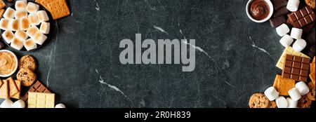 Buffet de smores à double bordure. Guimauves grillées, craquelins, chocolat et ingrédients variés. Vue ci-dessus sur un arrière-plan en pierre sombre. Banque D'Images