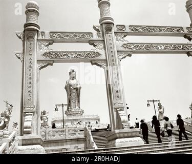 CHINE, personnes marchant devant la statue de Quan Yin, Putuoshan (B&W) Banque D'Images