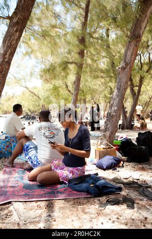 L'ILE MAURICE, les amis sont profiter de l'ombre et un pique-nique sur la plage de l'Ile aux Cerfs Island Banque D'Images