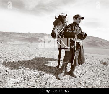 MONGOLIE, Shehperd Batsuuriin se tient avec son cheval Khaltar et regarde sa vie, le désert de Gobi, bassin de Nemegt (B&W) Banque D'Images