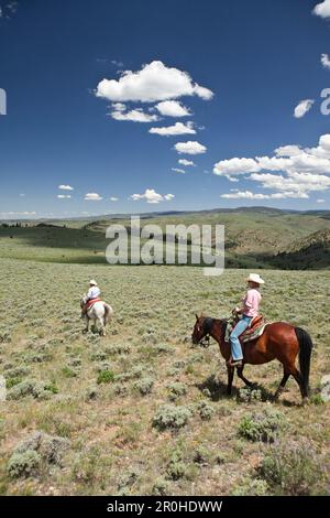 USA, Wyoming, du cantonnement, un cowboy et cowgirl ride à travers un paysage sans fin, Abara Ranch Banque D'Images
