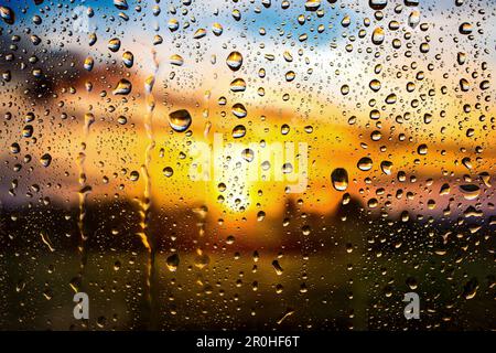 Gouttes de pluie sur un panneau de fenêtre en automne au coucher du soleil, Allemagne Banque D'Images