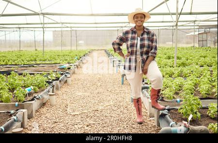 Fier fermier dans son jardin de récolte. Joyeux jeune agriculteur avec ses plantes. Portrait d'un jardinier souriant dans sa serre. Jeune agriculteur dans sa durabilité Banque D'Images