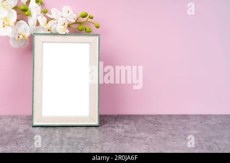 Cadre d'image vierge avec fleur d'orchidée blanche sur fond rose avec espace de copie et chemin d'écrêtage pour l'intérieur. Banque D'Images