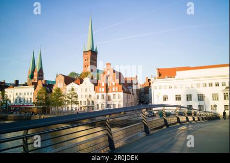 Pont piétonnier traversant la rivière Trave, jardin d'hiver et églises de la rue Pierre et Saint Marie en arrière-plan, ville historique, Lubeck, Schleswig-Holstein, Banque D'Images