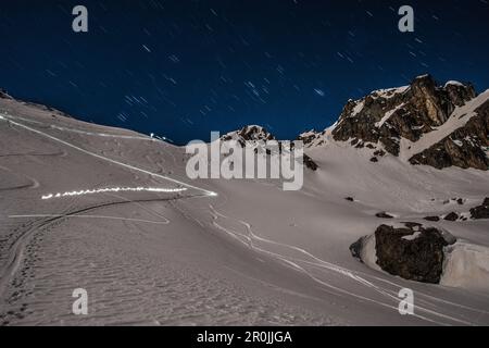 Les amateurs de ski à la lumière de la pleine lune (pistes d'ascension et de descente) près de la cabane de Grialetsch, Grisons, Suisse, Europe Banque D'Images