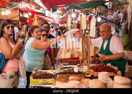 Les gens au stand delicatessen au marché de la rue Ballaro, Palerme, Sicile, Italie Banque D'Images