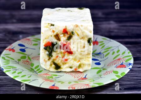 Assiette avec un cube de baril égyptien de fromage blanc de baramuli avec des tranches de poivrons rouges et verts, un fromage traditionnel du Moyen-Orient fait de table Banque D'Images
