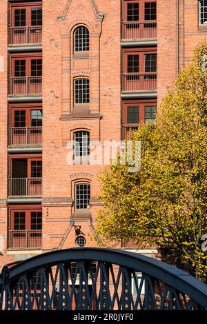 L'un des nombreux ponts de Hambourg avec vue sur l'un des entrepôts en briques rouges du quartier de Speicherstadt, qui fait partie du patrimoine mondial de l'UNESCO, Hambourg, GE Banque D'Images