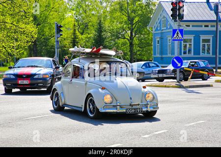 White Volkswagen Beetle et d'autres voitures d'époque environ 450 participant au salon Maisema Cruising 2019 font la queue dans la circulation urbaine. Salo, Finlande. 18 mai, 201 Banque D'Images