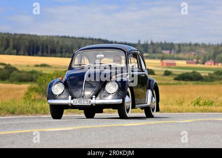 Black Volkswagen Beetle, officiellement Volkswagen Type 1, conduite le long de la route de campagne sur Maisemaruise 2019 voiture de croisière. Vaulammi, Finlande. 3 août 2019. Banque D'Images