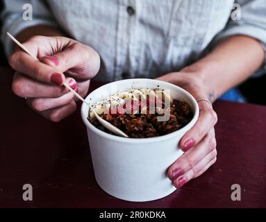 Commencez toujours votre journée par le petit déjeuner. une femme méconnaissable ayant un bol de granola. Banque D'Images