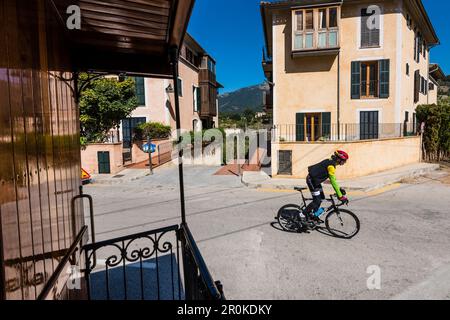 Vue depuis le train historique entre Sóller et Palma sur une rue avec l'un des nombreux cyclistes, Bunyola, Mallorca, Espagne Banque D'Images