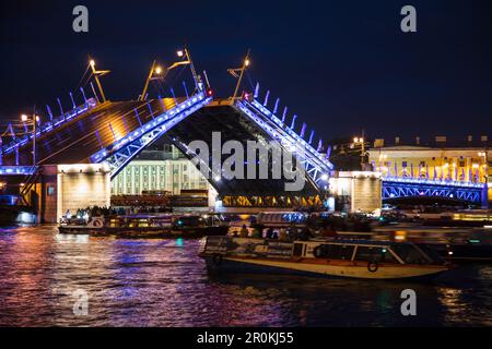 'Les bateaux passent le pont de Dvortsovy (pont du Palais) ouvert sur la rivière Neva pendant ''les nuits blanches'' avec le musée illuminé de Kunstkamera derrière au concert Banque D'Images