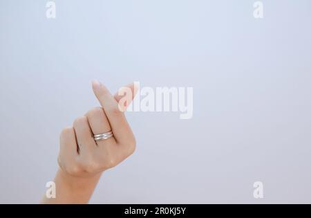 main femelle montrant le petit coeur sur un fond blanc isolé, gros plan mini coeur signe par les femmes main Banque D'Images