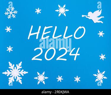 Carte de vœux du nouvel an. Le texte HELLO 2024 sur fond bleu avec des flocons de neige de Noël, un ange blanc. Bonne année. Banque D'Images