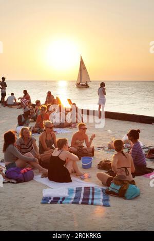 BELIZE, Caye Caulker, les touristes apprécient la plage et le coucher du soleil au Lazy Lizard Bar. Banque D'Images