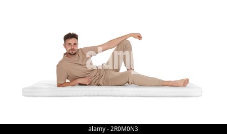 Homme allongé sur un matelas doux sur fond blanc Banque D'Images