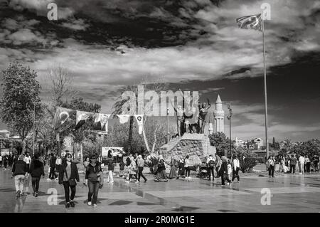 Les gens flânent sur la place de la République à côté de la statue du héros national Mustafa Kemal Ataturk sur un cheval à Antalya, Turquie (Turkiye). Dans la distance m Banque D'Images