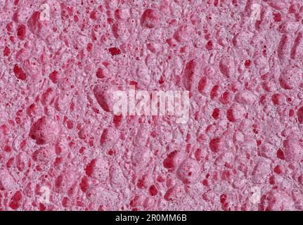 Texture d'une éponge rose poreuse en gros plan comme un arrière-plan abstrait Banque D'Images