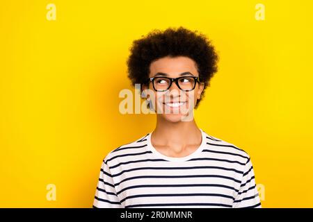 Photo portrait de gai jeune étudiant gars look vide espace porter rayé blanc noir t-shirt isolé couleur jaune arrière-plan Banque D'Images