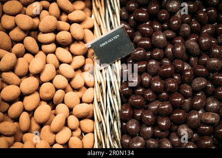 Vue de dessus des tas assortis de cacahuètes émaillées placées dans des paniers en osier avec inscription sans gluten sur le comptoir dans le marché local de Barcelone Banque D'Images