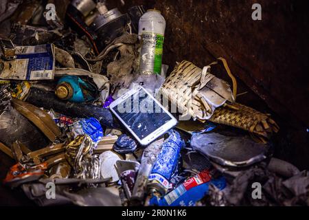 09 mai 2023, Mecklembourg-Poméranie occidentale, Rosenow: Un téléphone cellulaire cassé avec une batterie rechargeable se trouve dans un conteneur de collecte pour les matières dangereuses à l'installation de tri de la société d'élimination des déchets REMONDIS Seenplatte GmbH. Une mise au rebut incorrecte des batteries et des batteries rechargeables provoque environ 30 incendies chaque jour en Allemagne, principalement dans les entreprises de mise au rebut des déchets. L'Association fédérale de l'industrie allemande de gestion des déchets (BDE), la société d'élimination des déchets OVVD et le district de Müritz présentent une campagne sous la devise "Focus: Battery" et informent sur les dangers de l'élimination de Banque D'Images