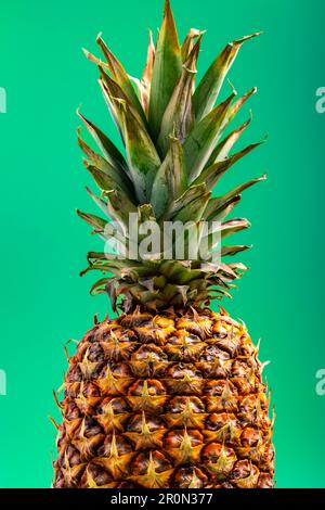 Vue rapprochée de l'ananas mûr entier sur fond vert Banque D'Images