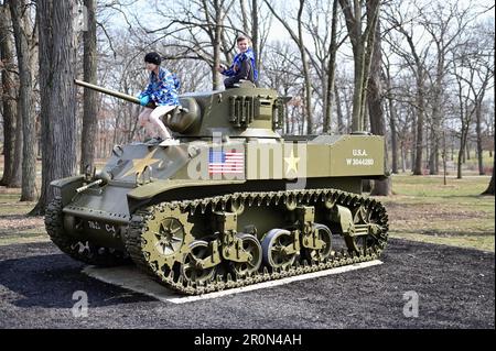 Wheaton, Illinois, États-Unis. Des enfants grimpent sur des chars militaires au parc Cantigny. Banque D'Images