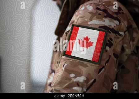 Soldat du Canada. Soldat avec drapeau du Canada, drapeau du Canada sur un uniforme militaire. Vêtements de camouflage Banque D'Images