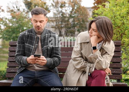 Homme ignorant sa petite amie et utilisant son smartphone à l'extérieur. Problèmes de relation Banque D'Images
