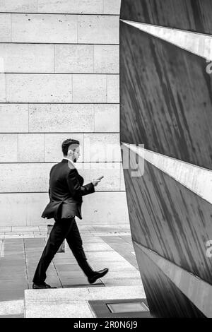 Homme marchant devant une sculpture intéressante dans la ville de londres Banque D'Images