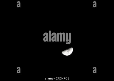 Une lune illumine le ciel nocturne, projetant une lumière brillante et argentée sur le paysage Banque D'Images