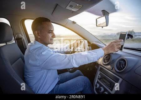 Conducteur utilisant le GPS de son téléphone mobile dans sa voiture. Banque D'Images