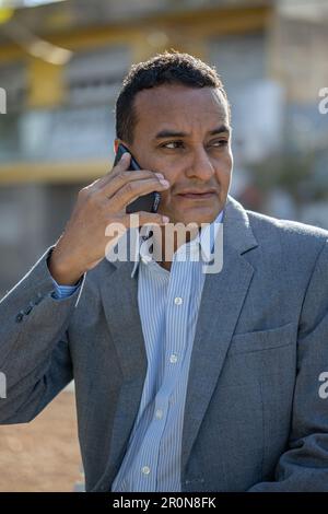 Photo moyenne d'un jeune latino parlant au téléphone. Banque D'Images