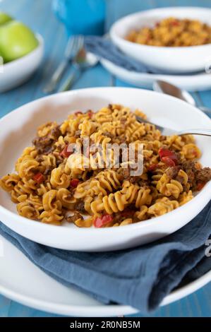 Plat de pâtes avec bœuf haché, tomates, poivrons, oignons et herbes sur une assiette Banque D'Images