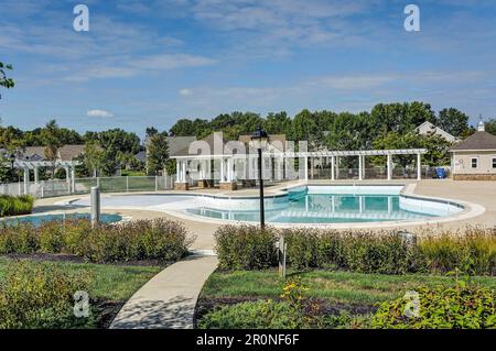 Une ambiance tranquille en plein air avec une piscine entourée d'un patio, avec un belvédère au loin Banque D'Images